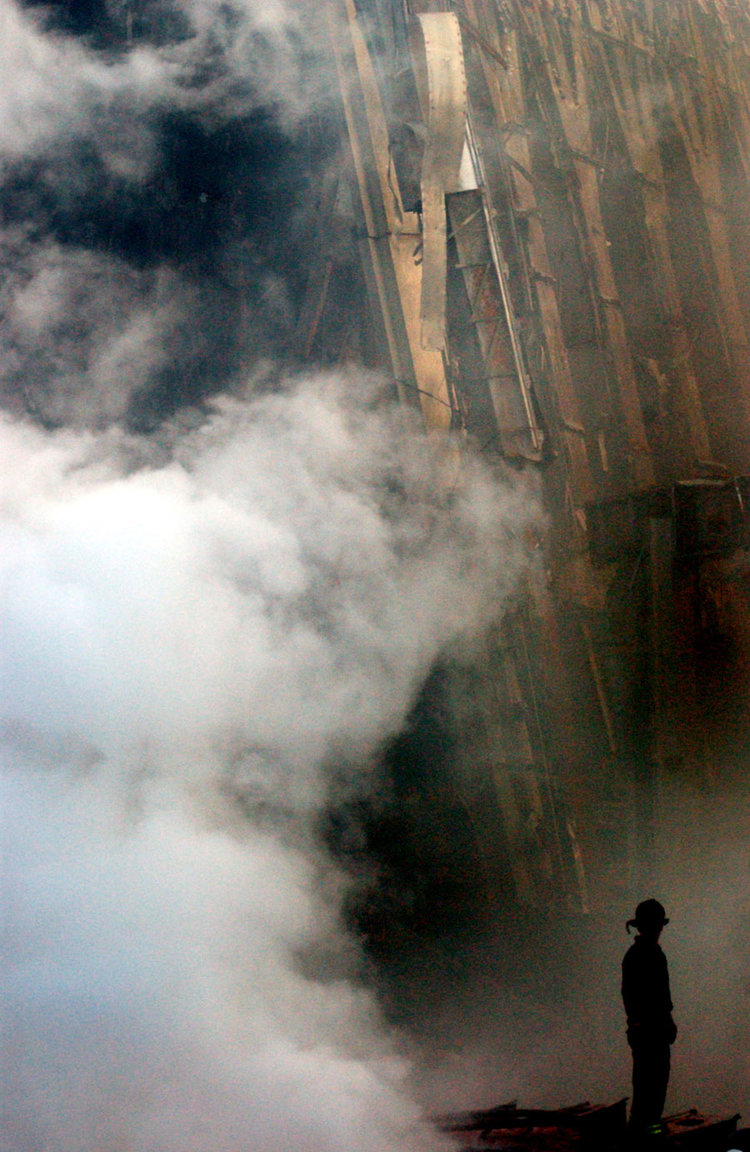 A lone firefighter stands amid the rubble, September 2001